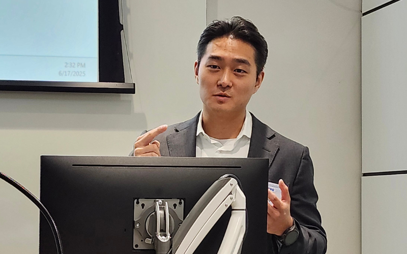 Jangho Yang at a podium giving a conference presentation