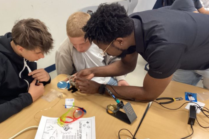 Tamoy Seabourne helps two students with an engineering project